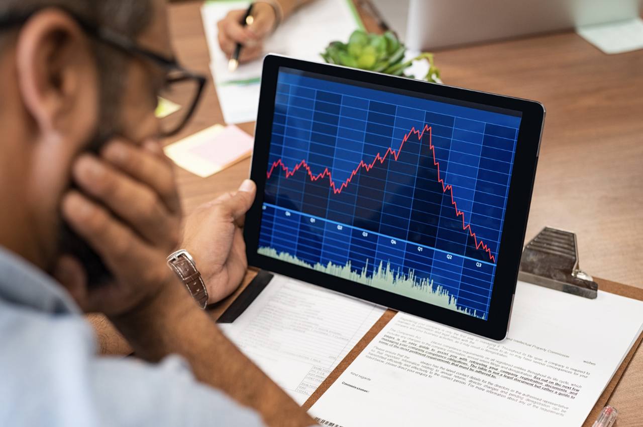 a man looking at laptop screen and watching the website crash stats and data