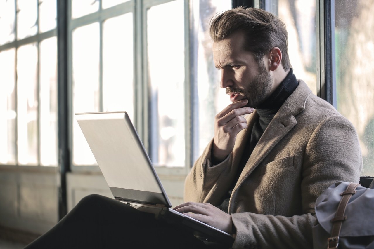 a man observing the details looking at his laptop