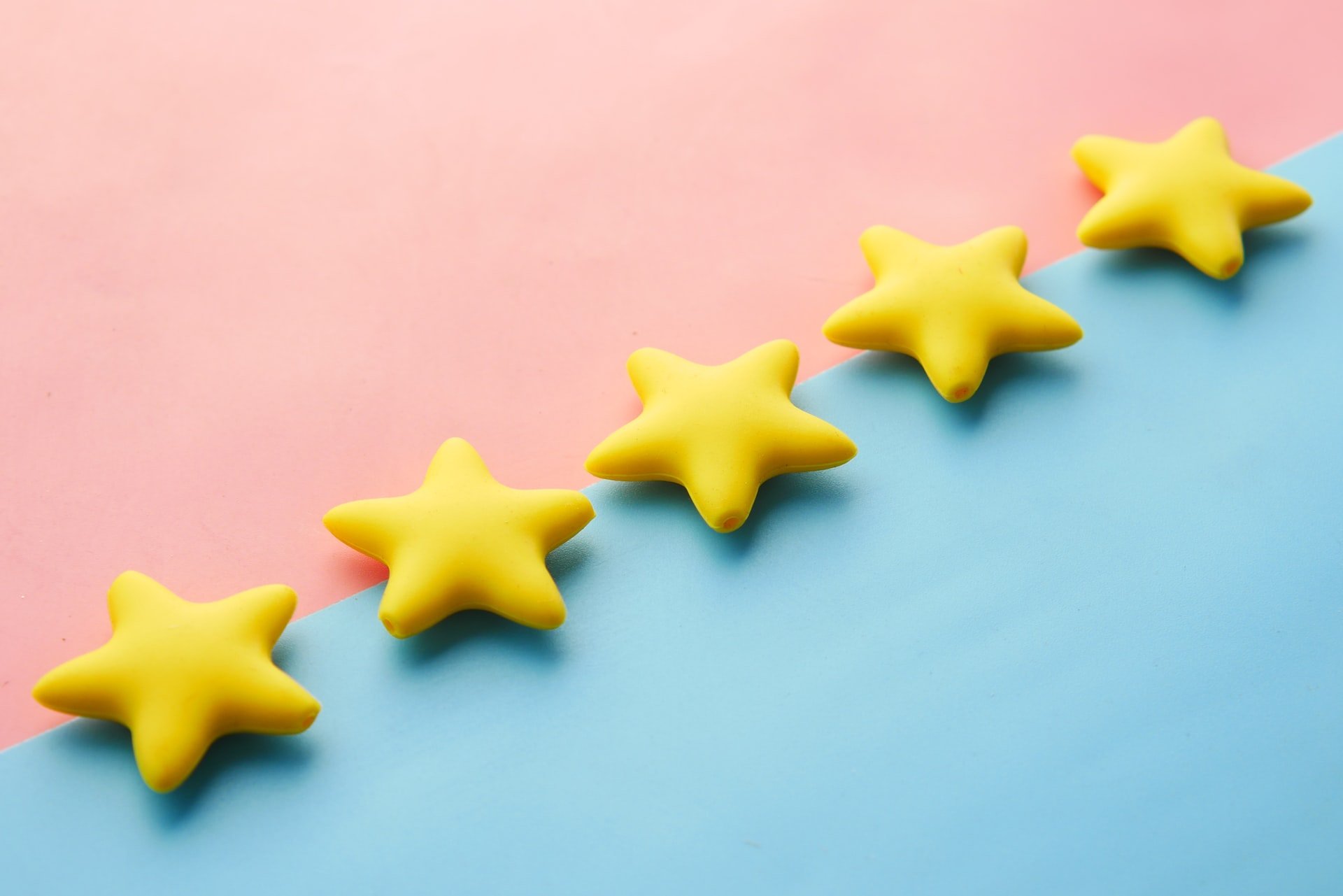 five yellow stars with a pink and blue background