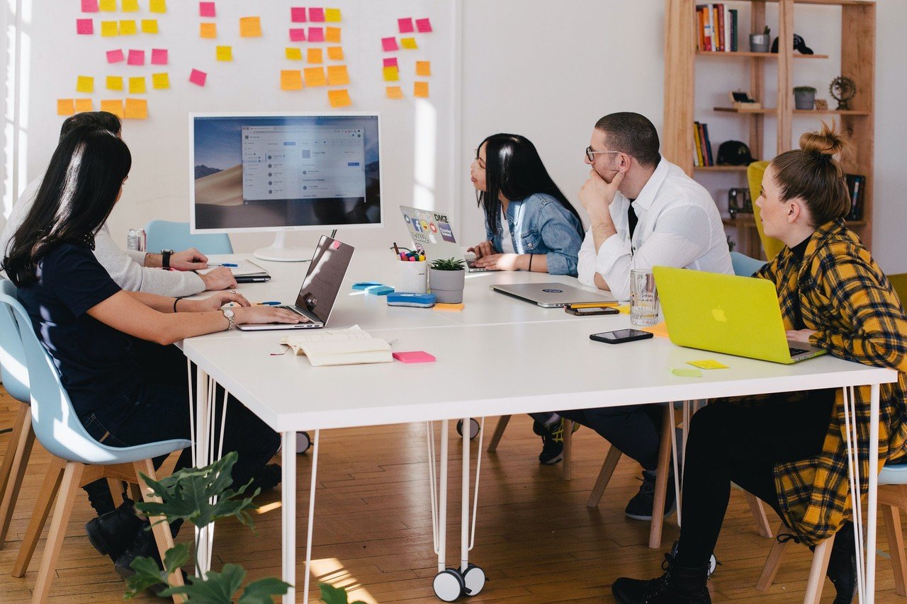 team members working together with their laptops and sticky notes on the wall