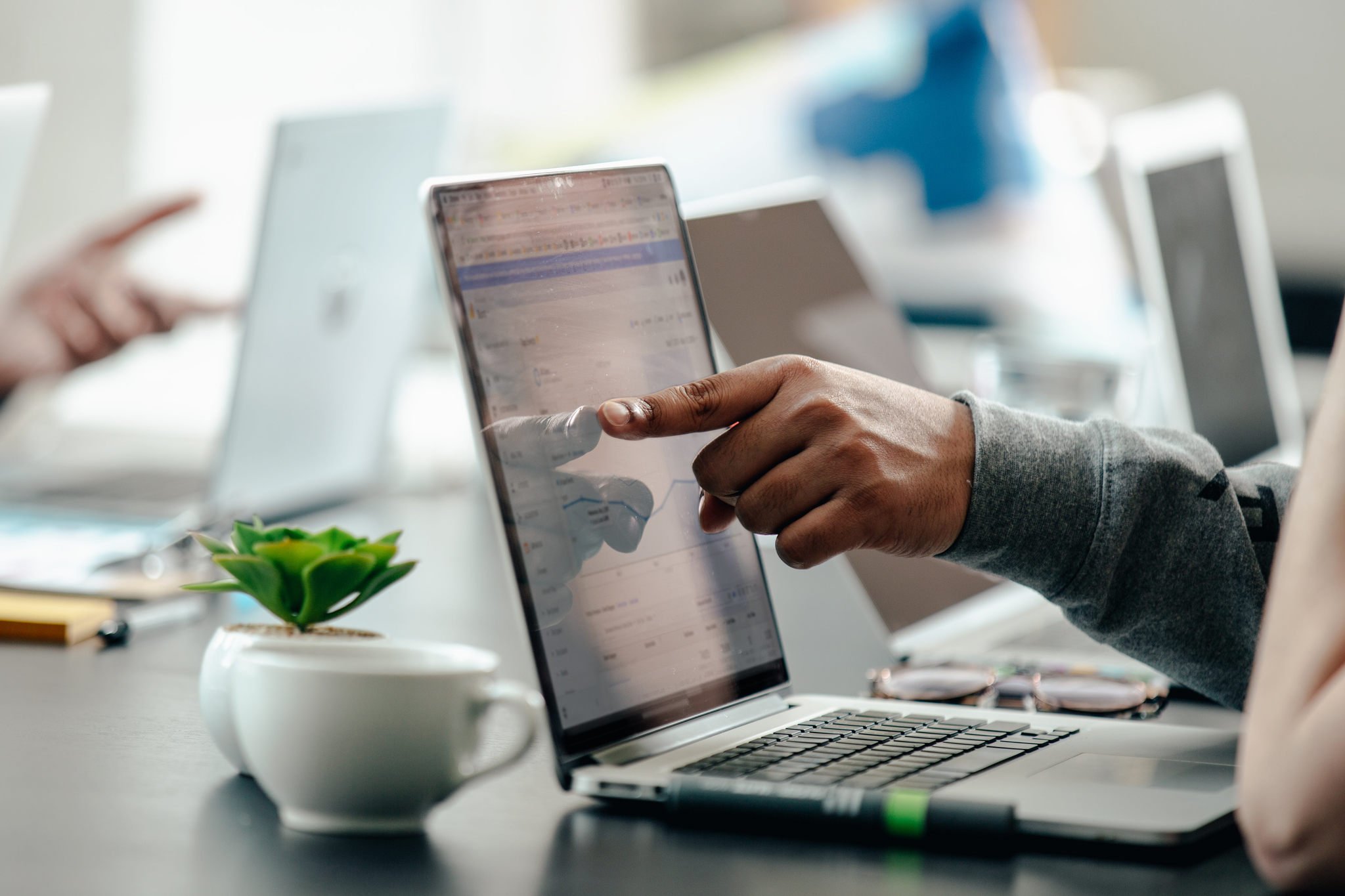 a man pointing at laptop screen with analytics