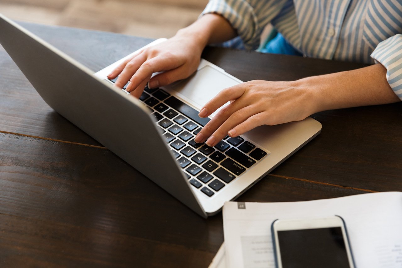 close up of a businesswoman typing blog post on laptop