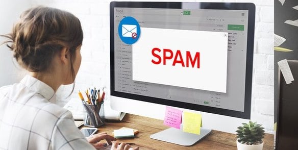 a girl working on her computer and her email goes to spam