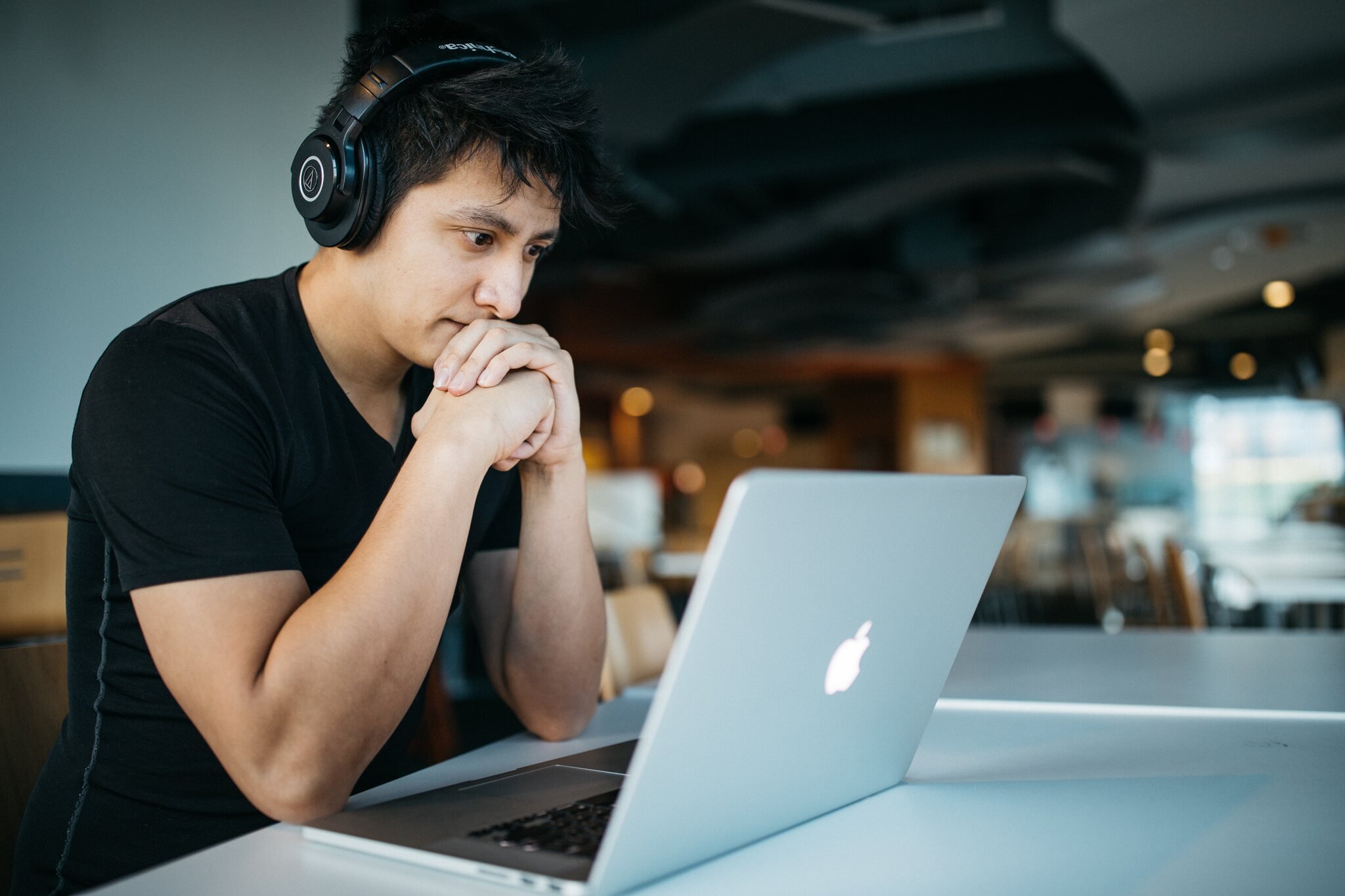 a man wearing headphones and checking laptop screen