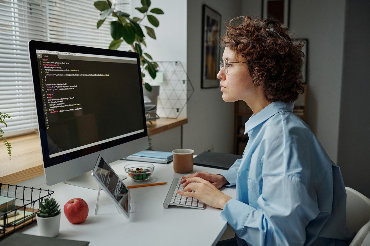 a business woman writing codes on computer