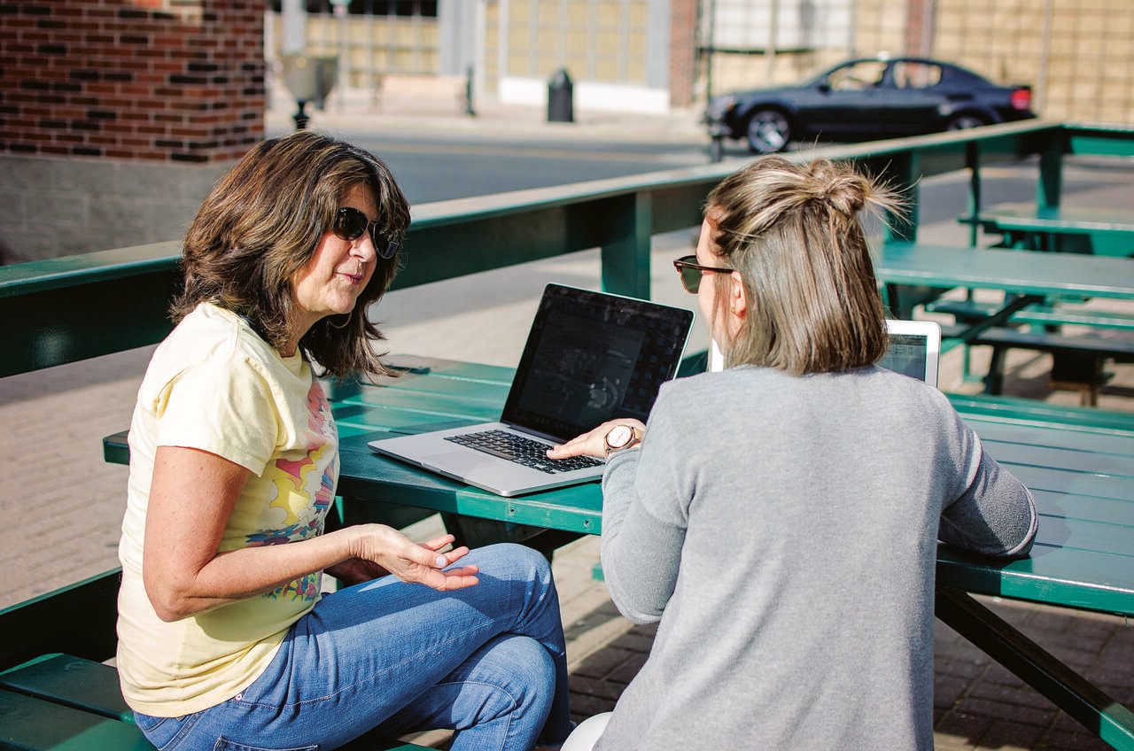 coworkers working outside and asking questions to each other