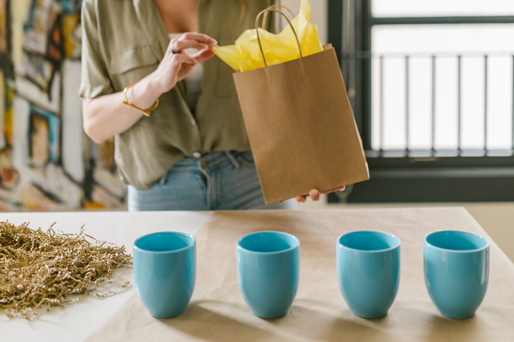 a woman preparing packages and cups on the table