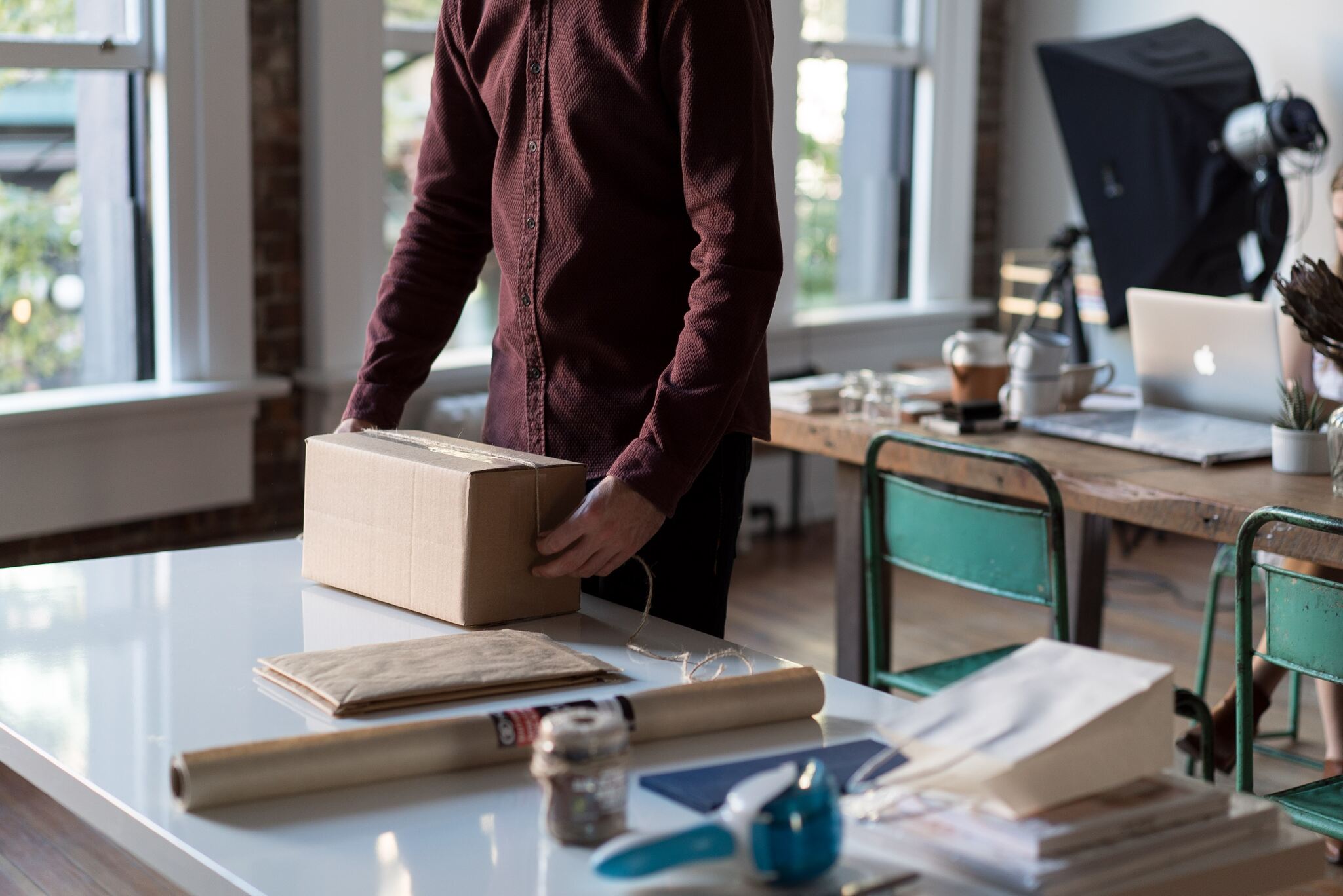 a person holding cardboard box on table