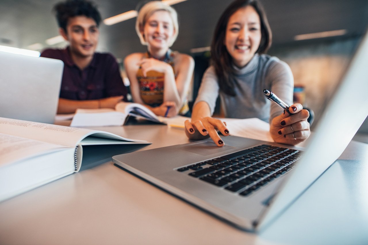 group of happy friends working on laptop