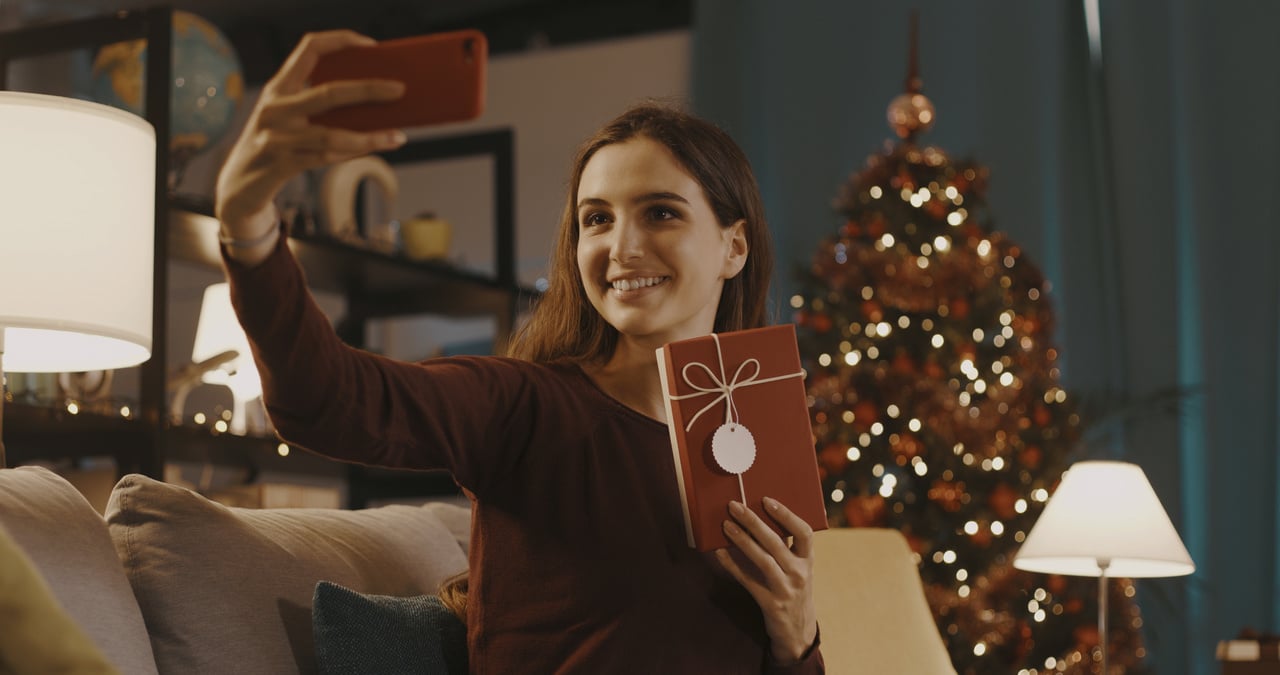 happy woman taking a selfie with her christmas gift