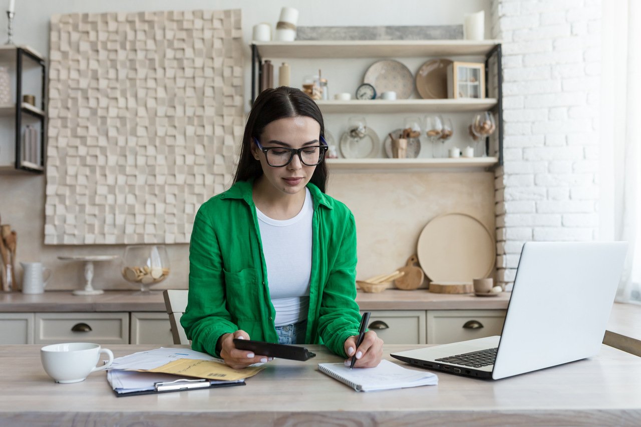 woman with a green coat working and taking notes