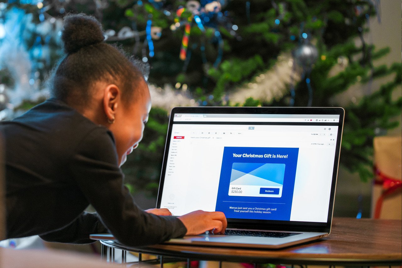 a child opening an email on the computer and smiling while opening