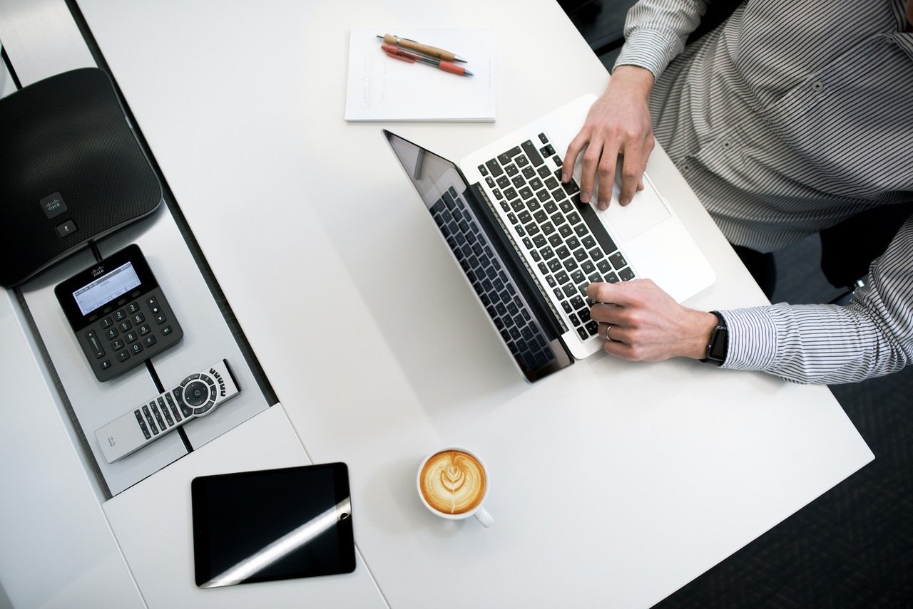 a person using a laptop on a white table