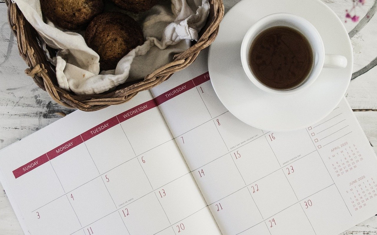 a calendar with a cup of coffee and pastries