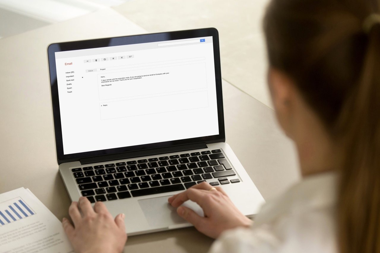 woman typing email on laptop