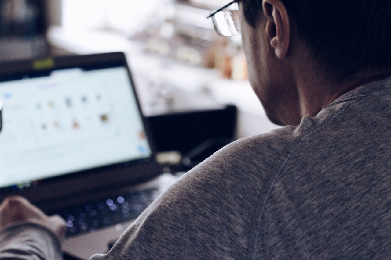 man using laptop with his back turned