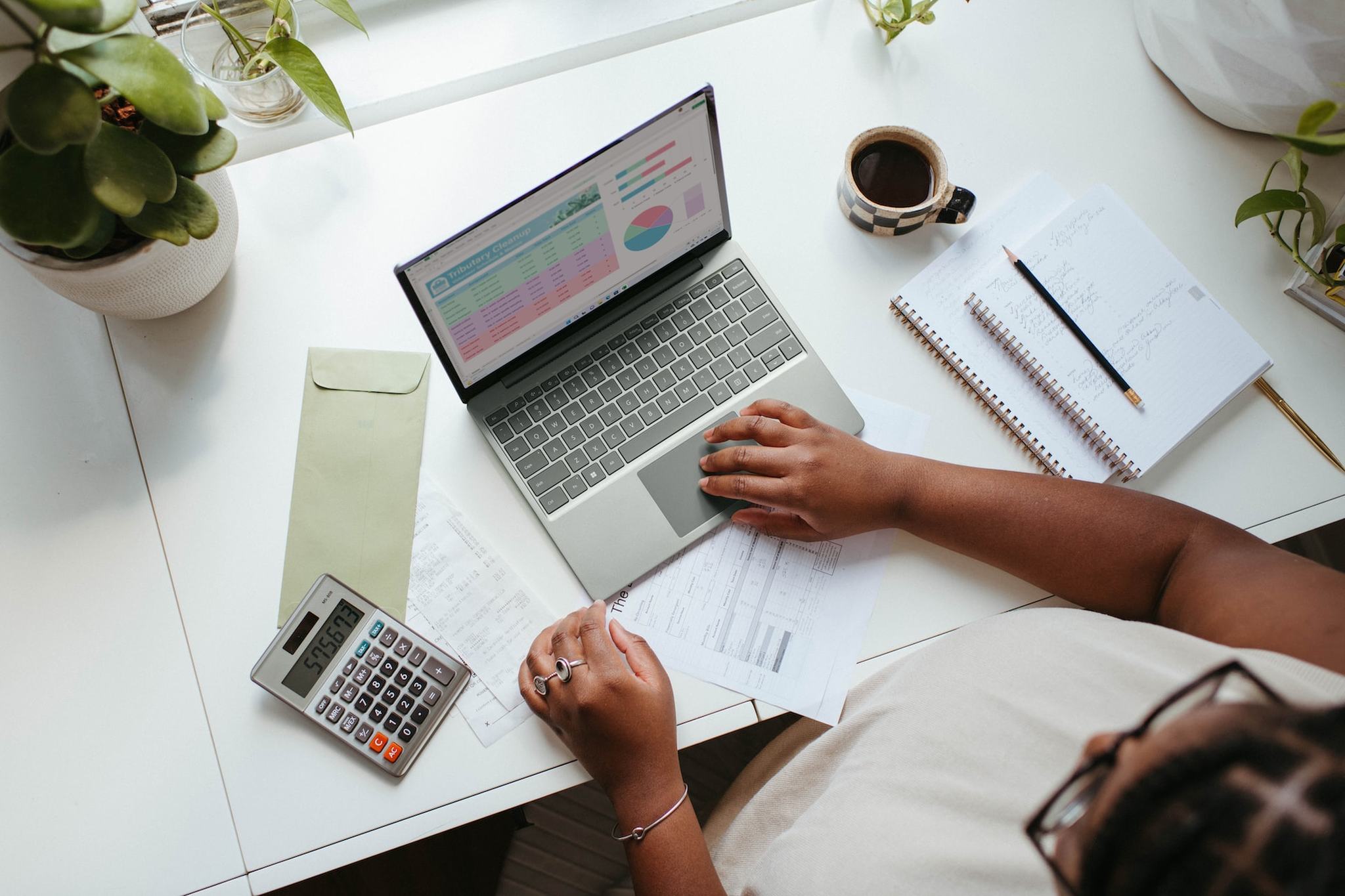 a person using calculator and a MacBook