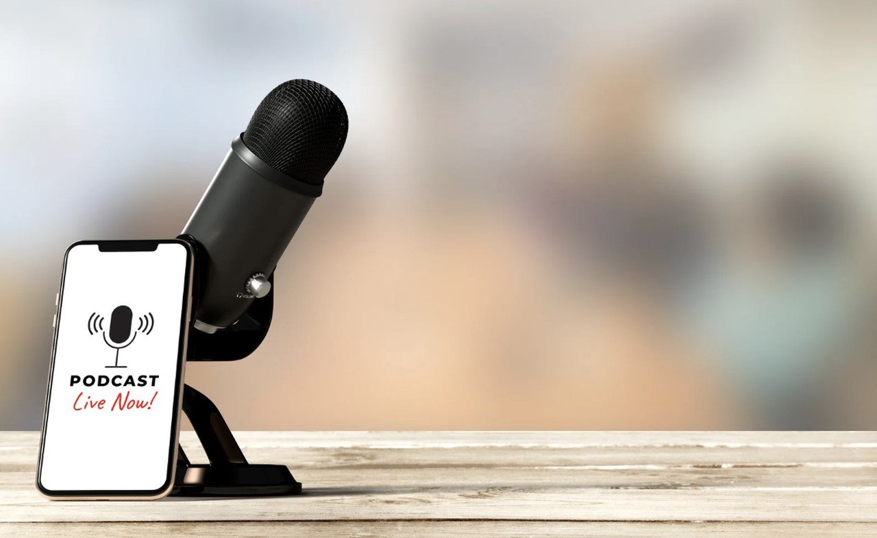 a smartphone playing ecommerce podcast with a black microphone next to it