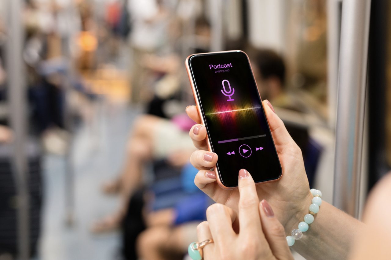 a woman's hands playing one of the best ecommerce and marketing podcast on her smartphone on the bus