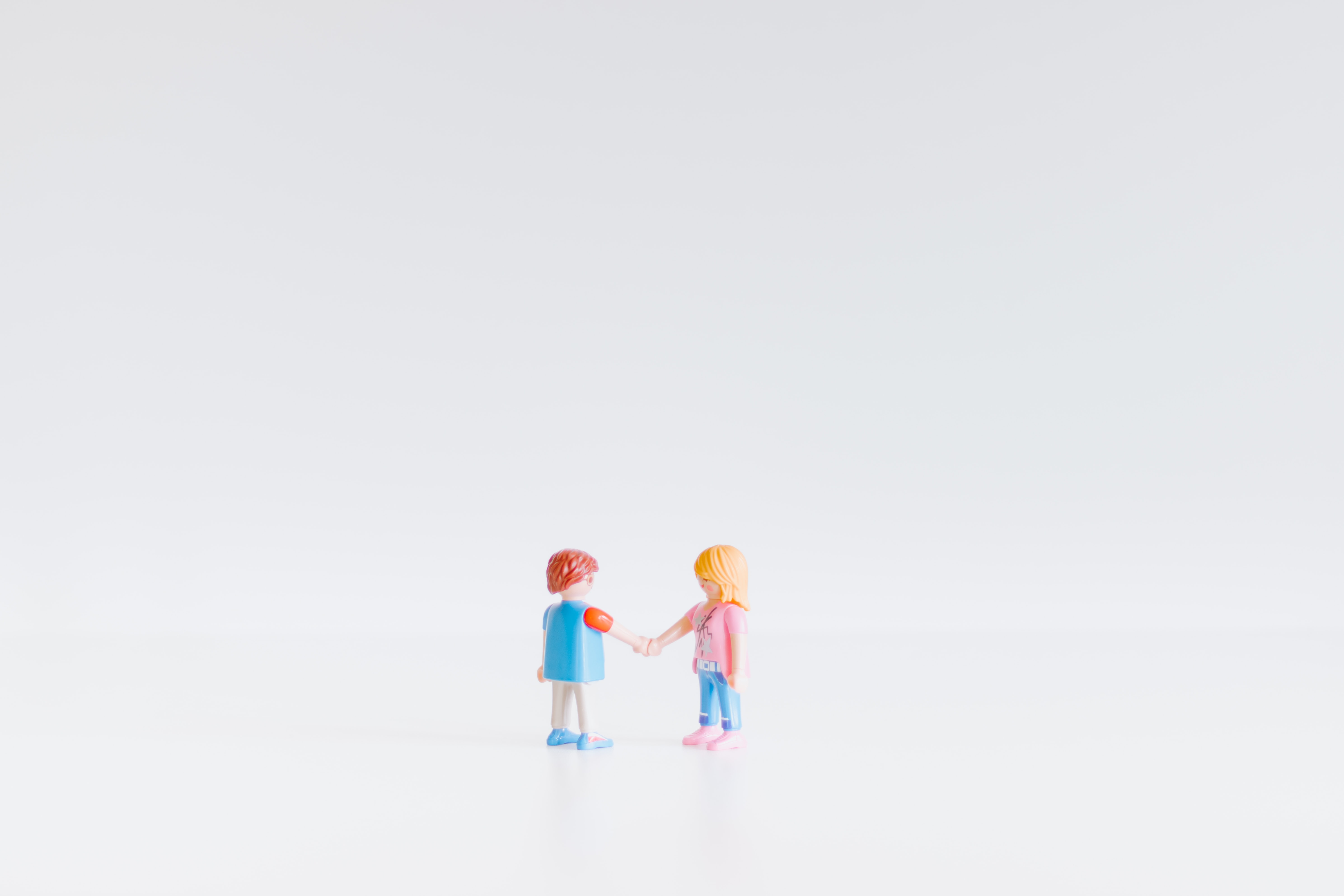 two little hand shaking lego figures on a light background