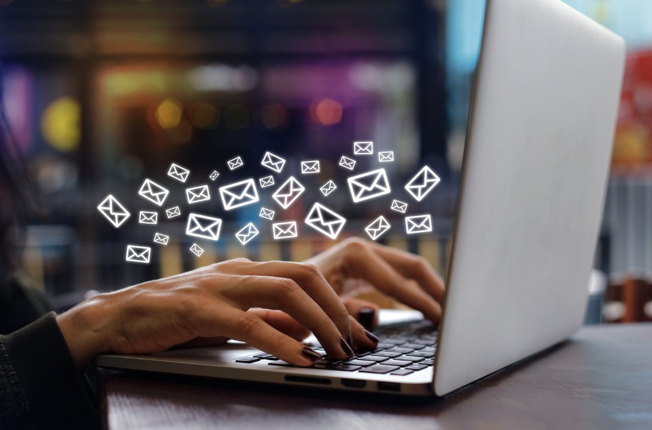 a photo of hands working with laptop sending emails