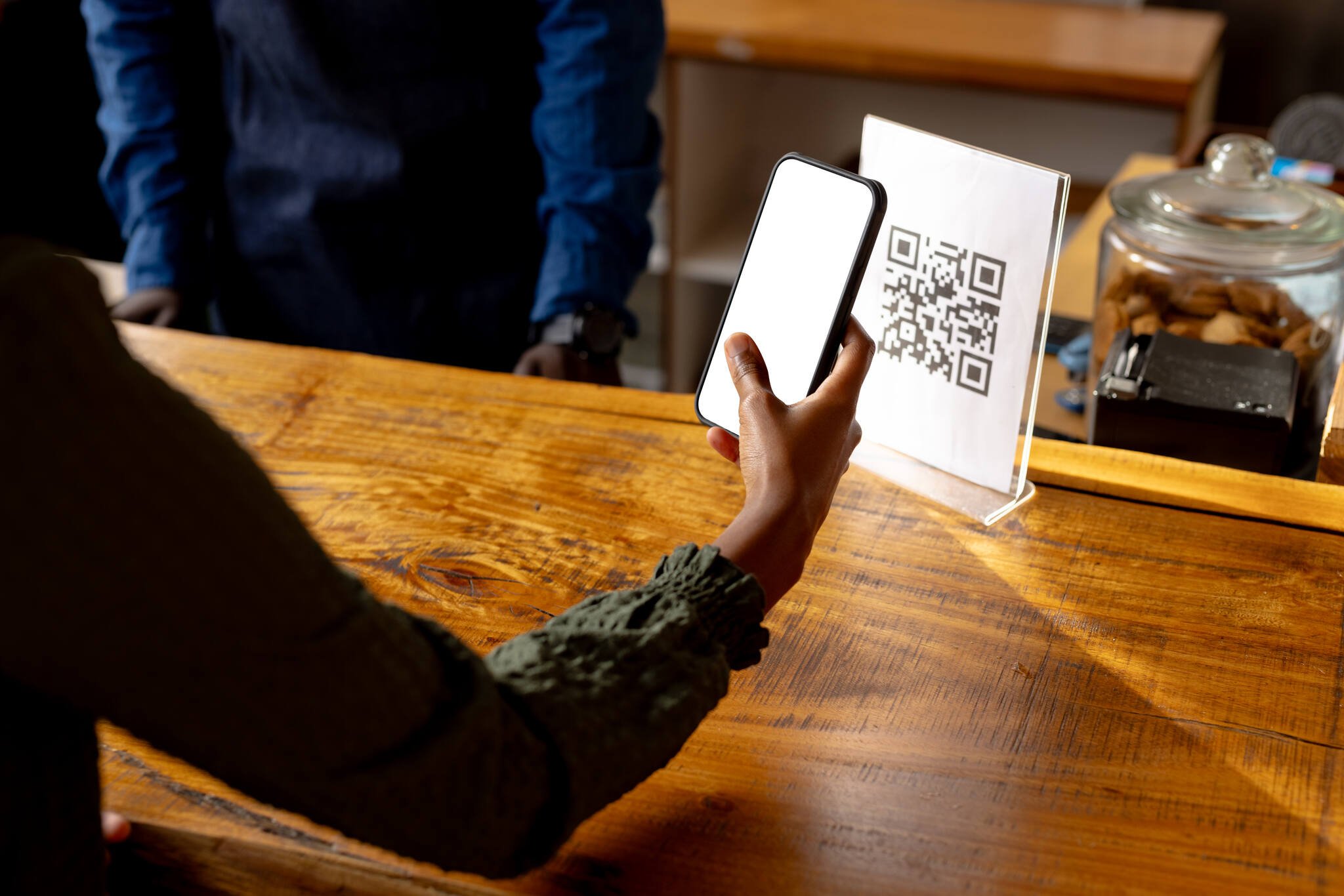 a hand of a woman scanning a QR code with a phone