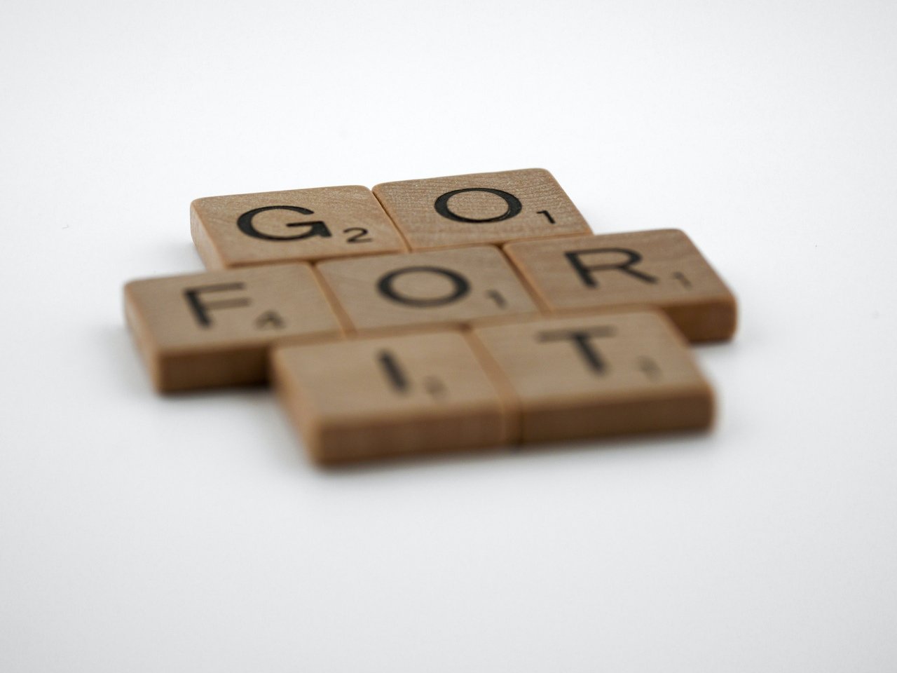 Scrabble pieces forming "Go For It" on a white background