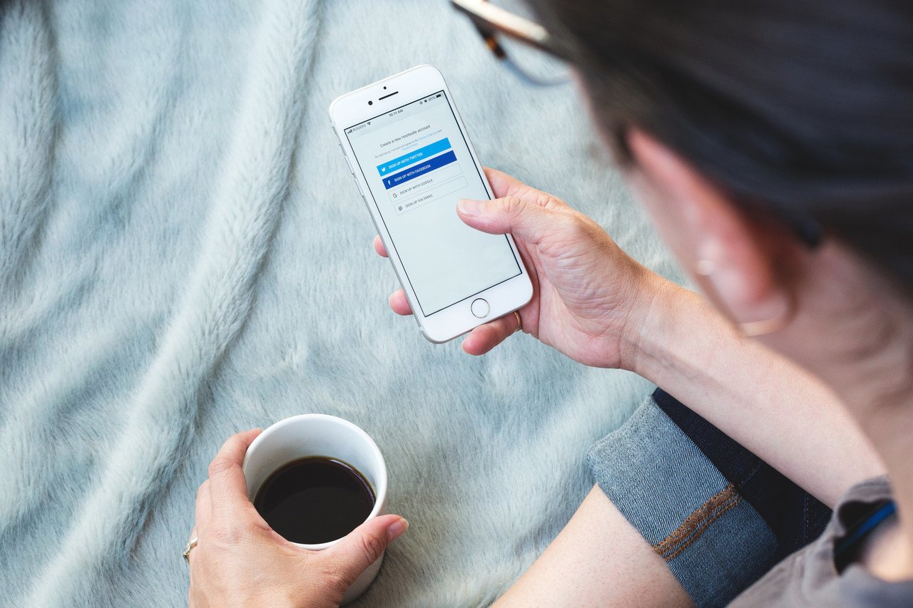 a woman drinking coffee and checking her phone