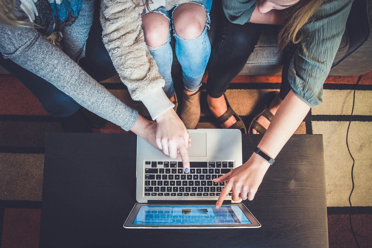 people pointing at a laptop