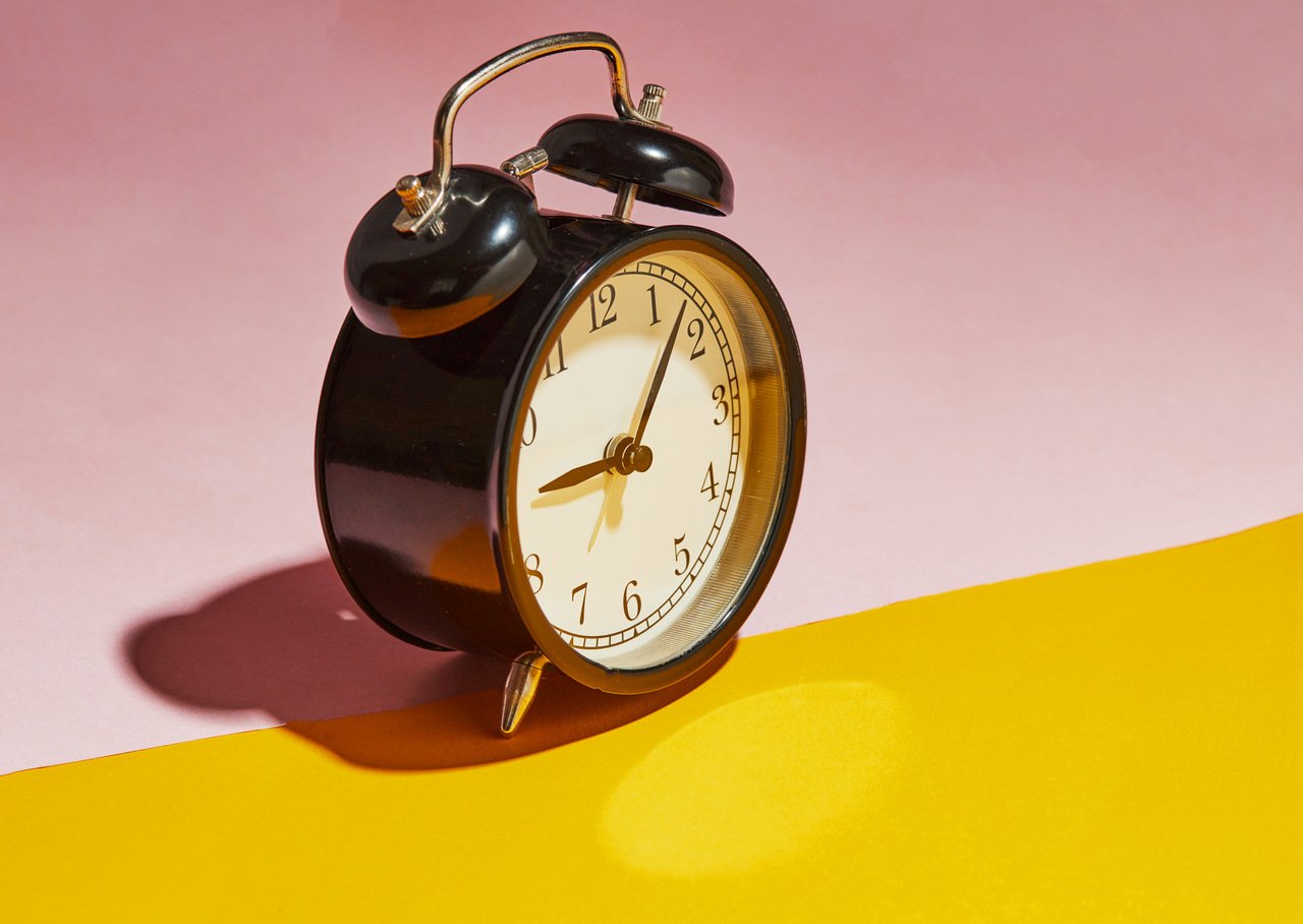 a table clock on a yellow and pink colored layer