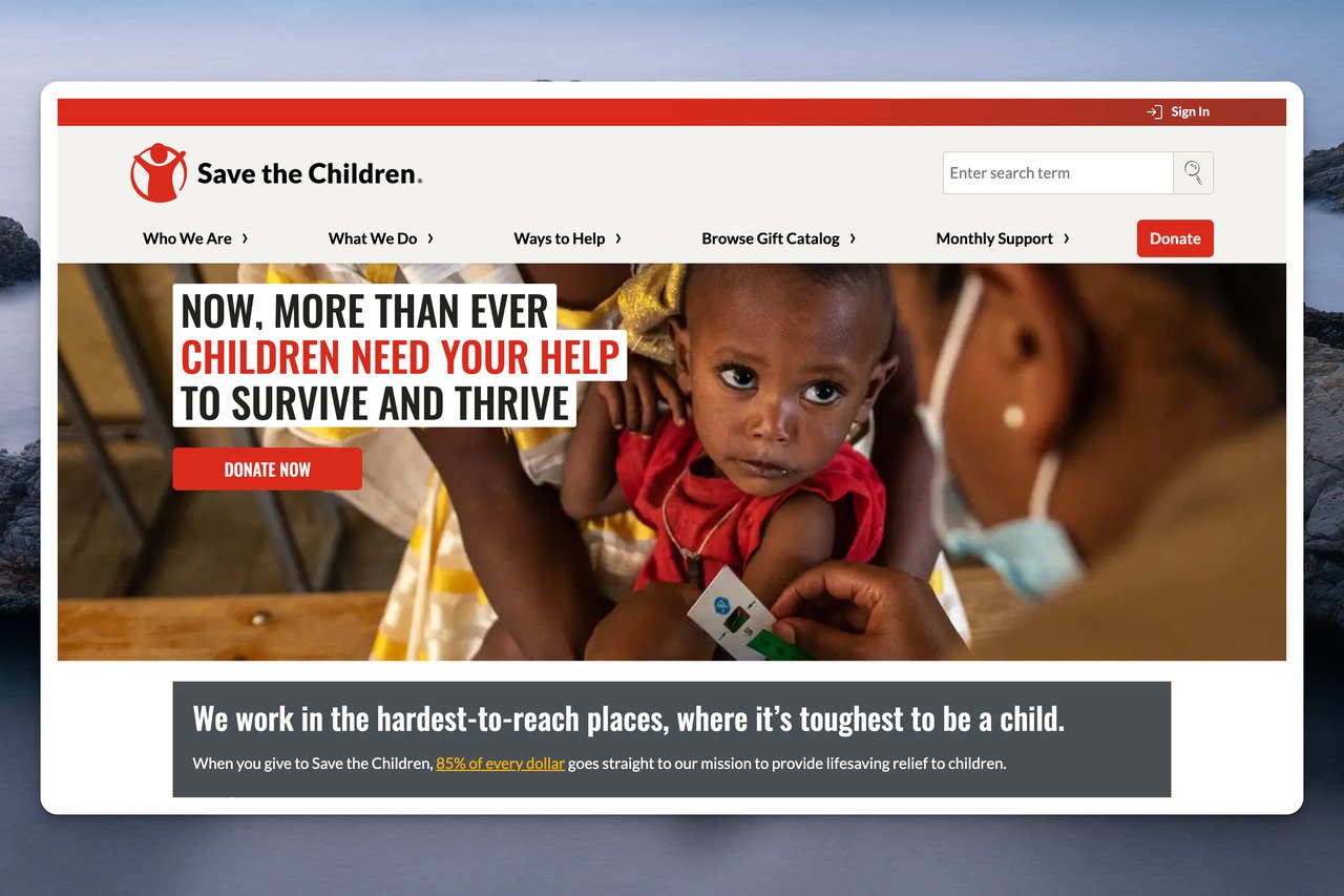 Save the Children website's homepage with the headline in black and red on a picture of a little child and another person's side profile is visible