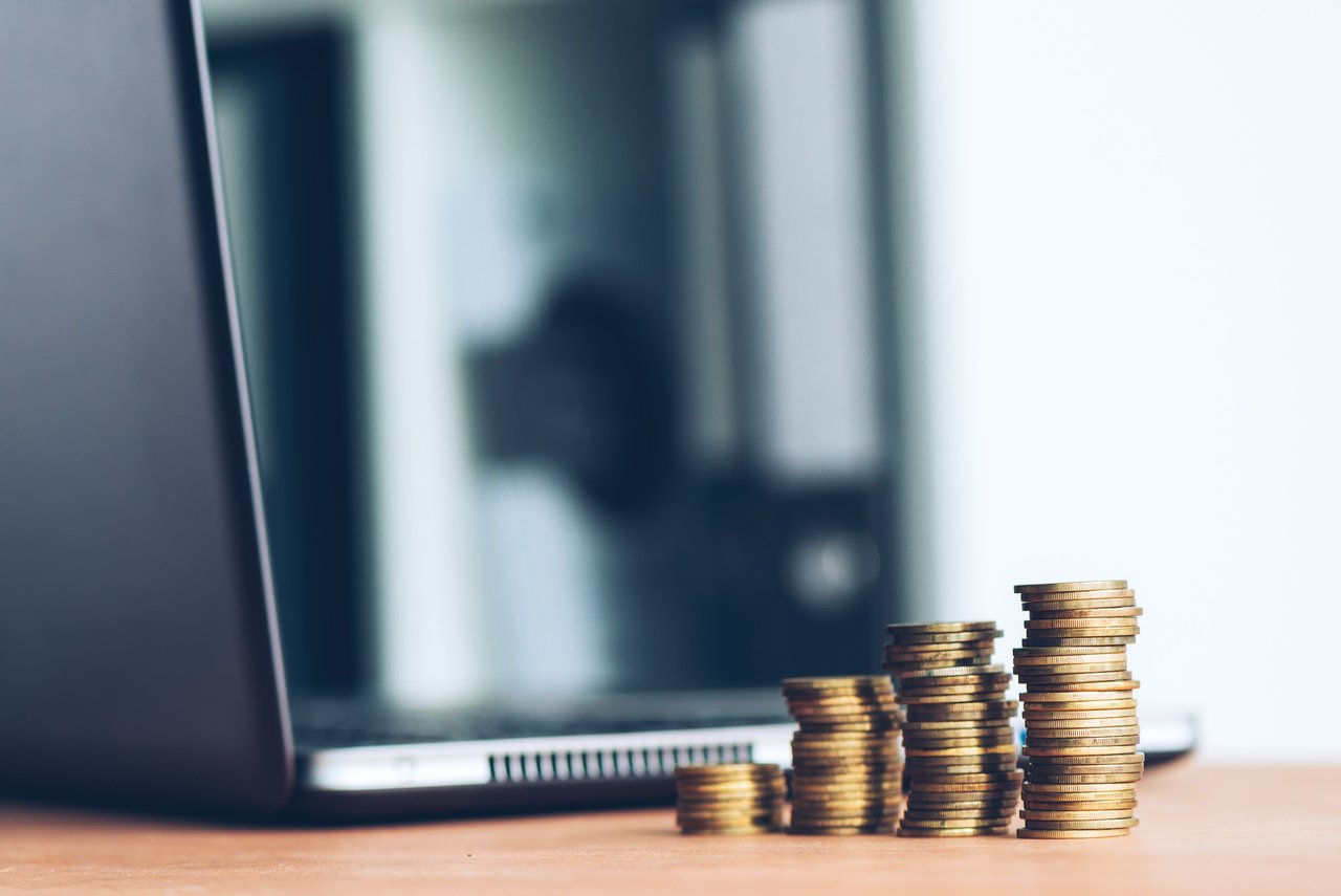 stack of coins near laptop