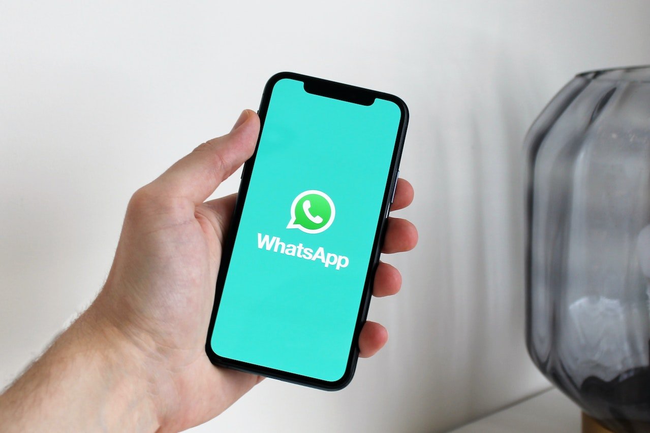 a person holding a phone with WhatsApp logo