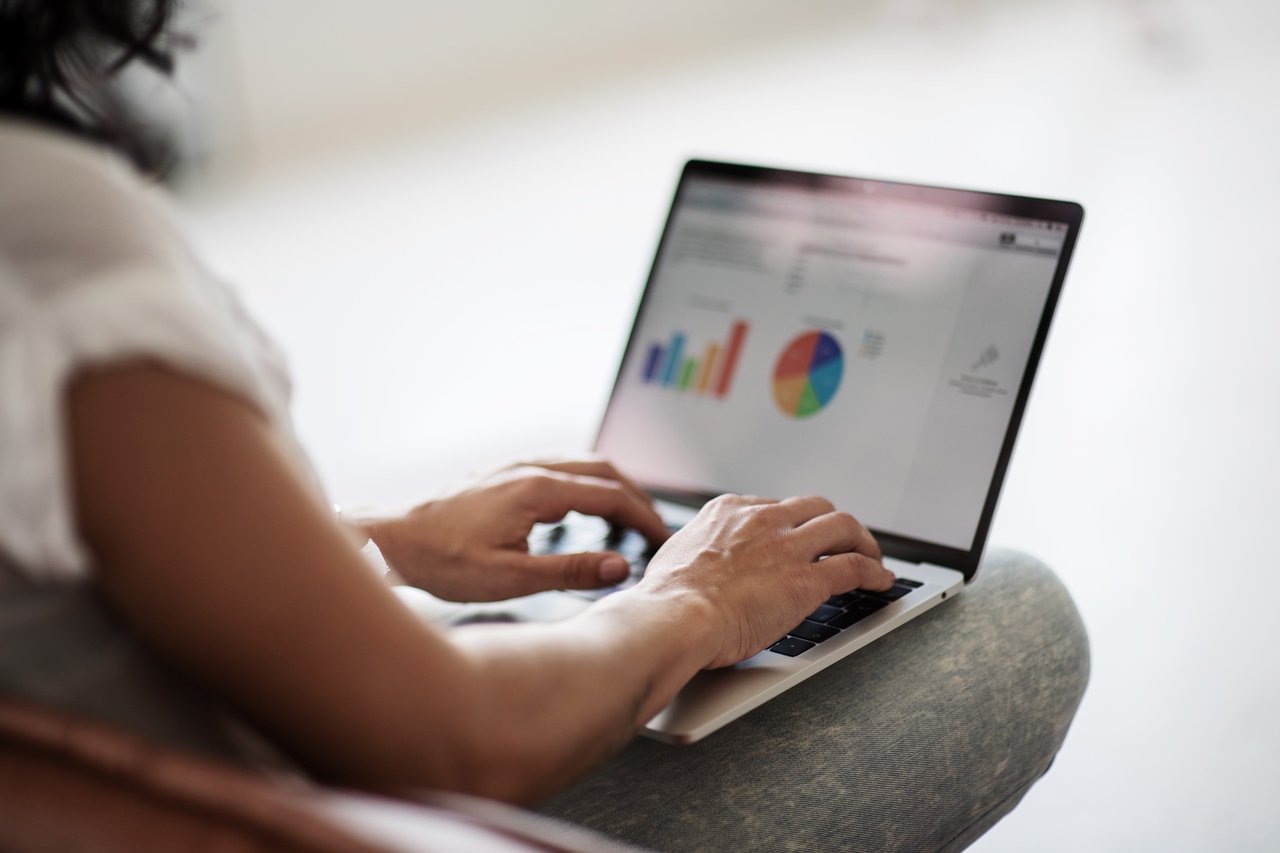 woman looking at graphs and charts on laptop screen