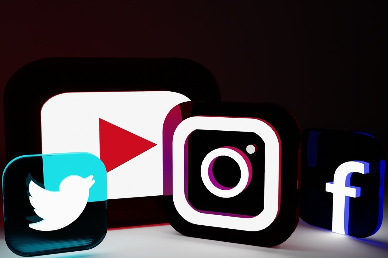 social media platform logos including Twitter, YouTube, Instagram and Facebook with neon colors on a black background