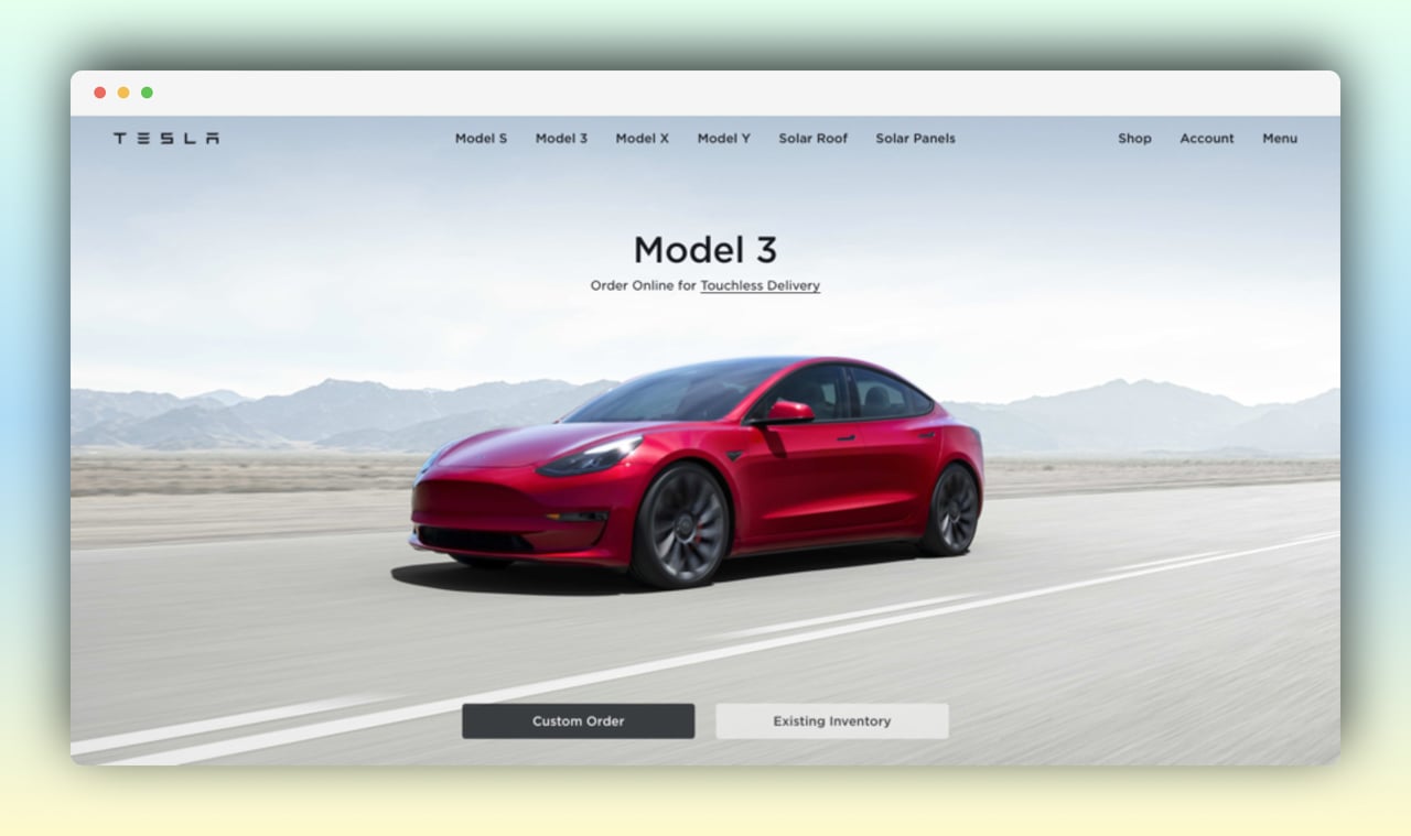 tesla homepage featuring a red Tesla car on the road with custom order and existing inventory buttons below