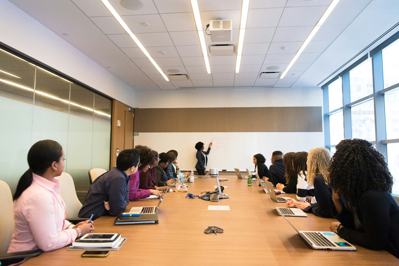 a team listening to a presentation made by a woman lead