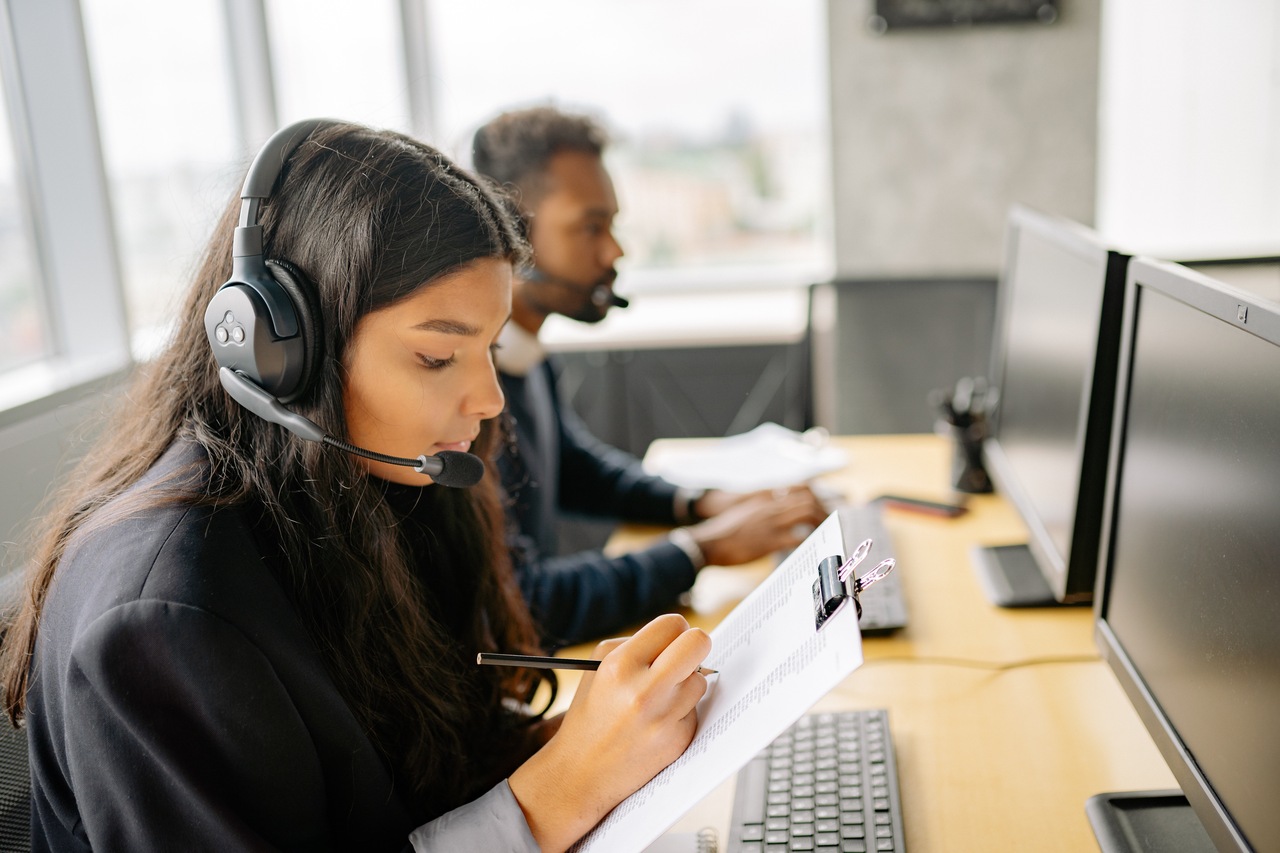 a girl wearing headphones and writing on a paper