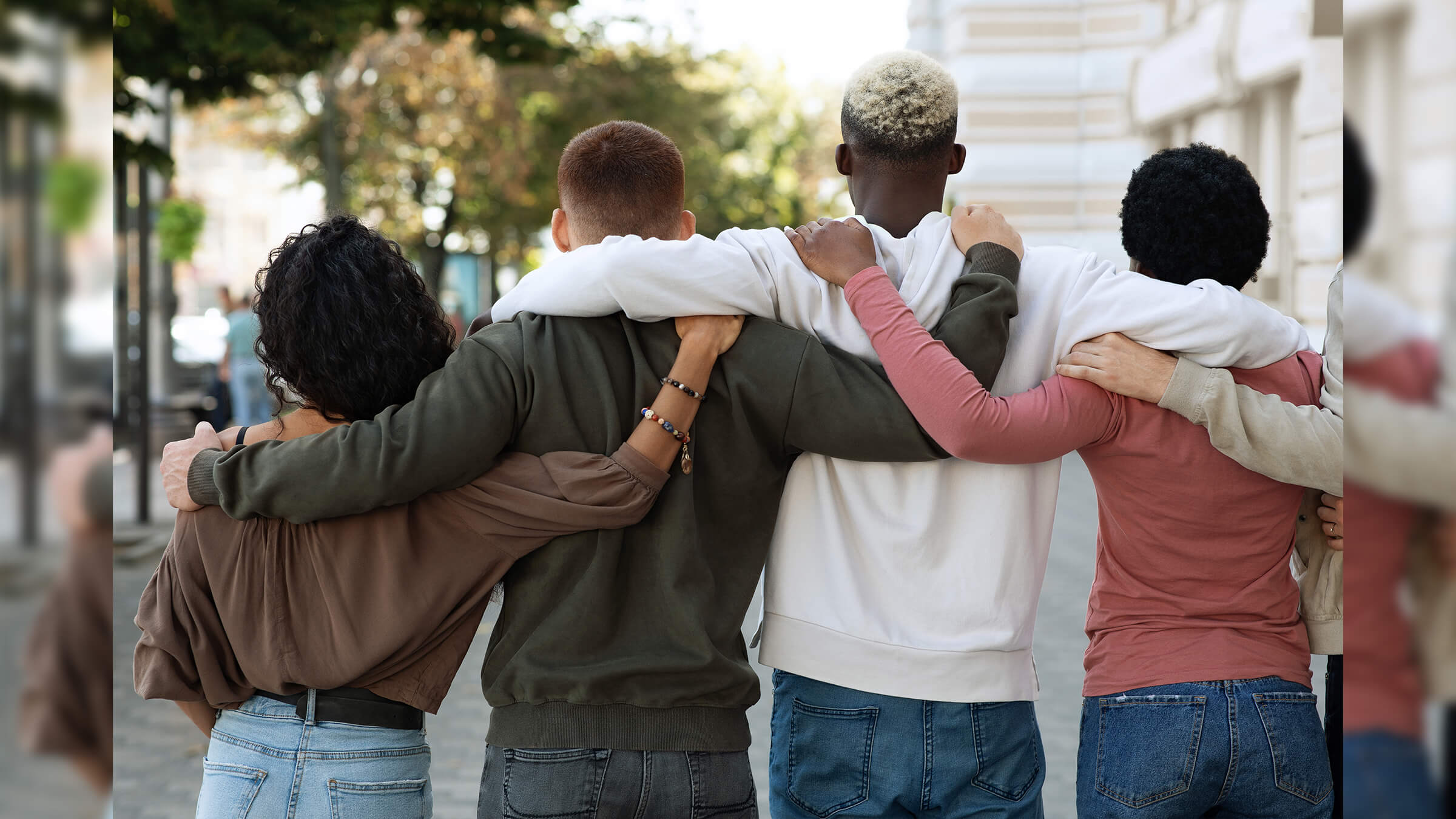 Back view of people hugging on the street