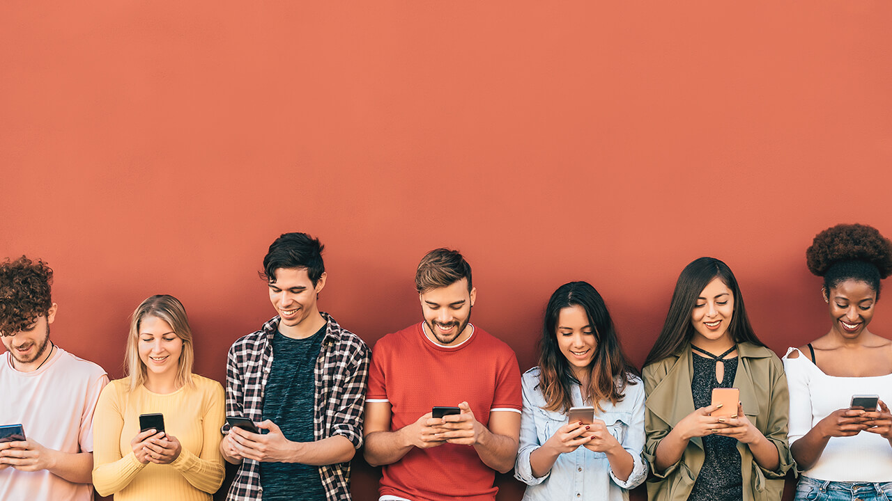 Group young people using mobile smartphone outdoors