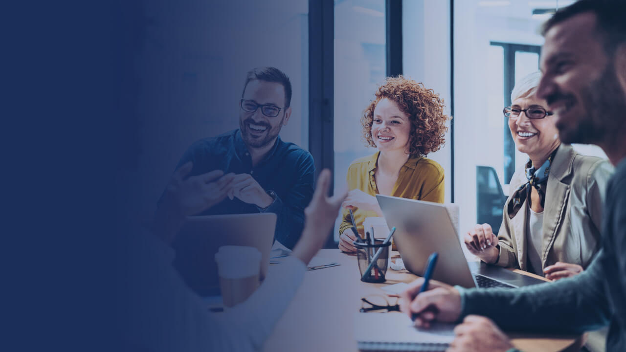 four people smiling in a meeting