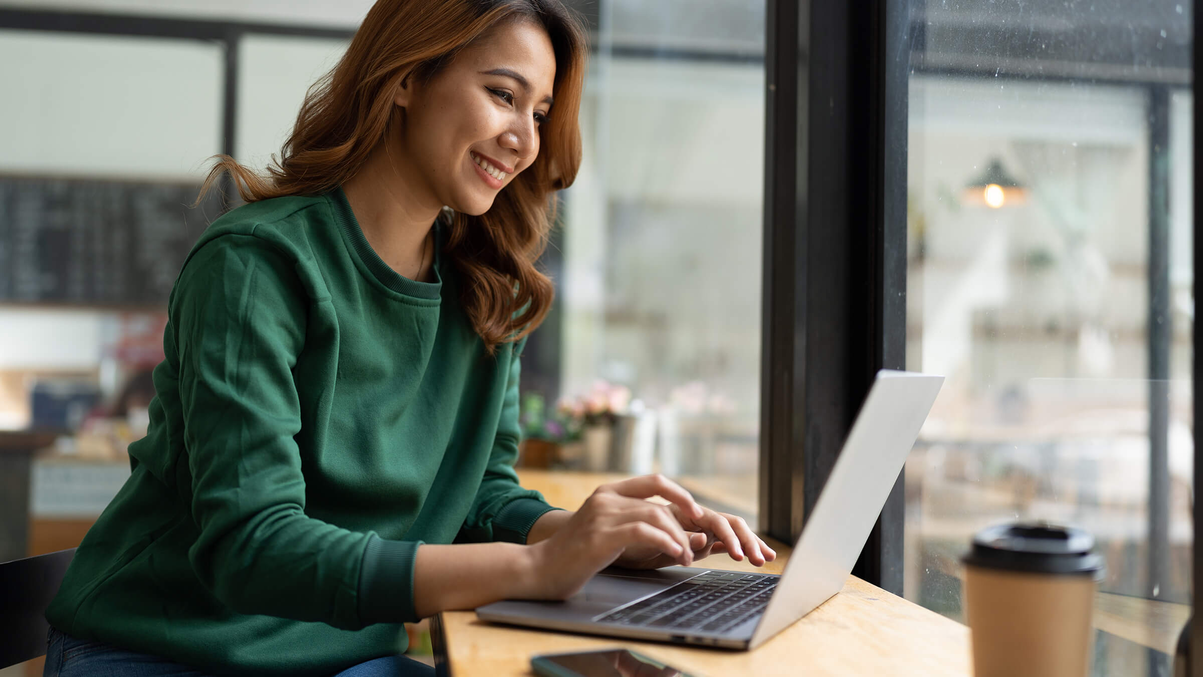 Young woman on his laptop in coffee shop