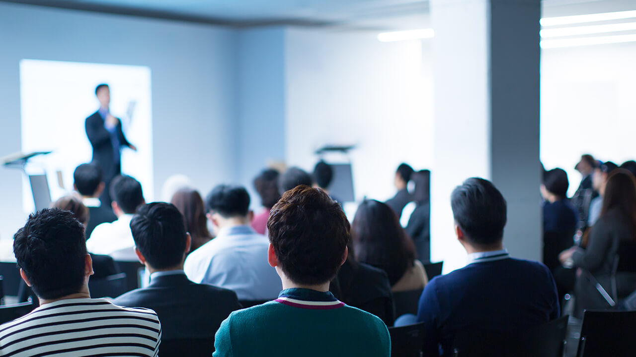 Seminar in front of crowd}