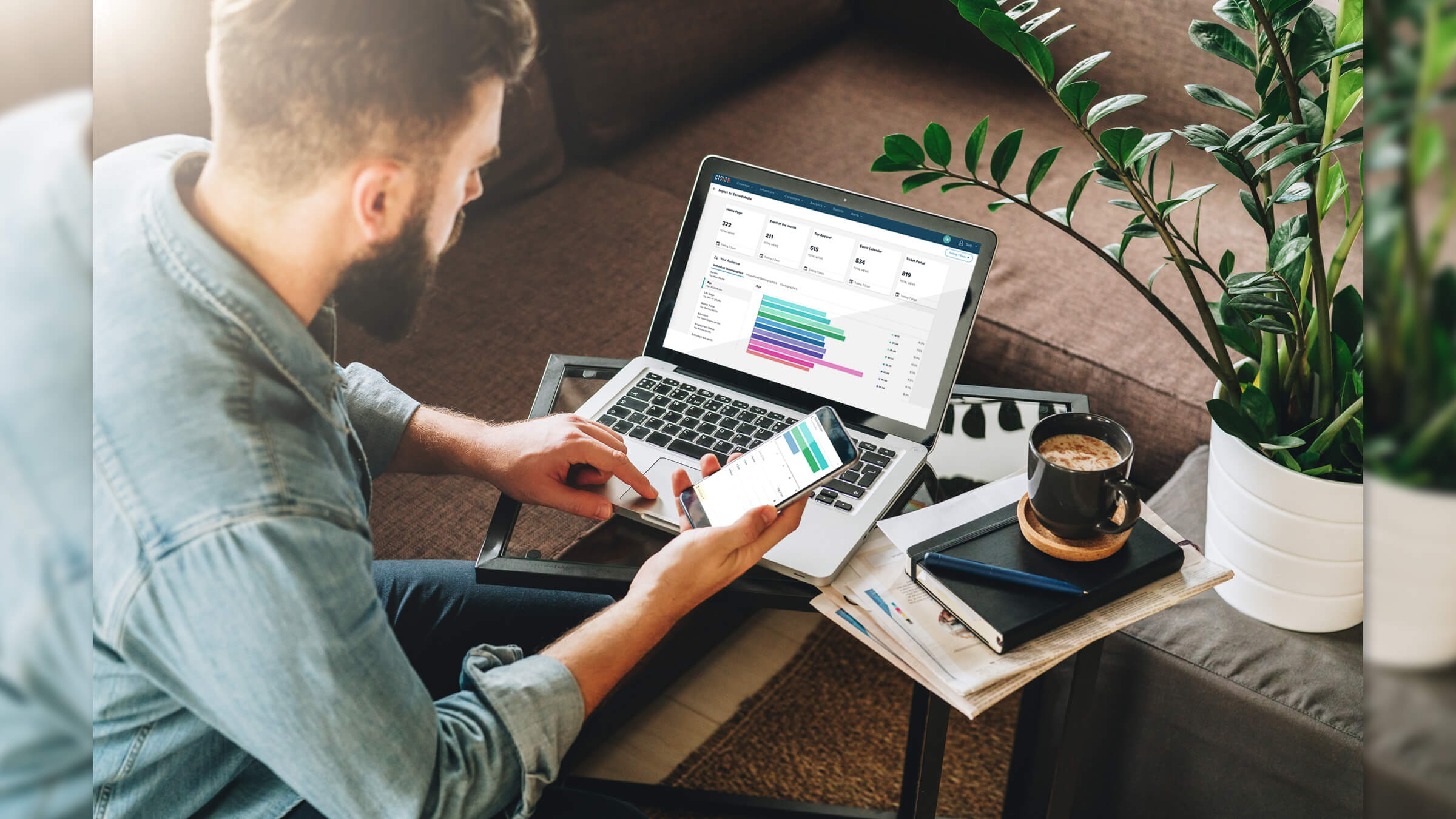 Person reviewing data on smartphone and laptop