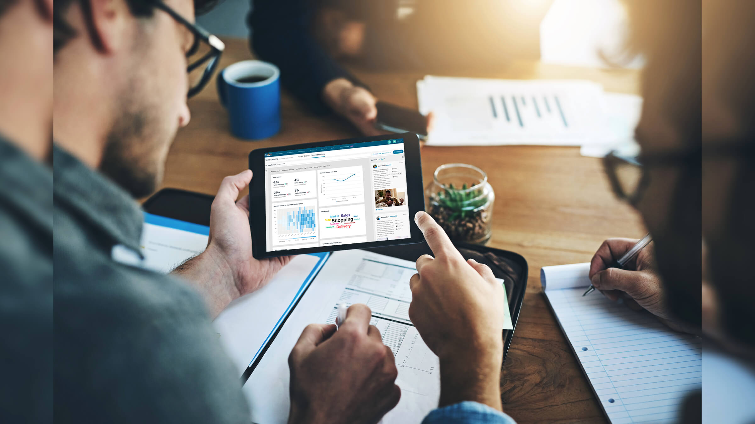 Two people pointing at tablet with analytics